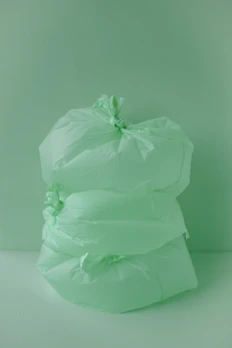 Various sizes of green-themed biodegradable bags arranged neatly on a wooden surface.