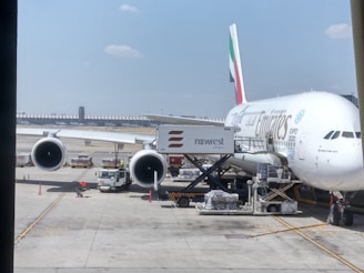 An airplane being loaded with cargo at an airport under clear skies.
