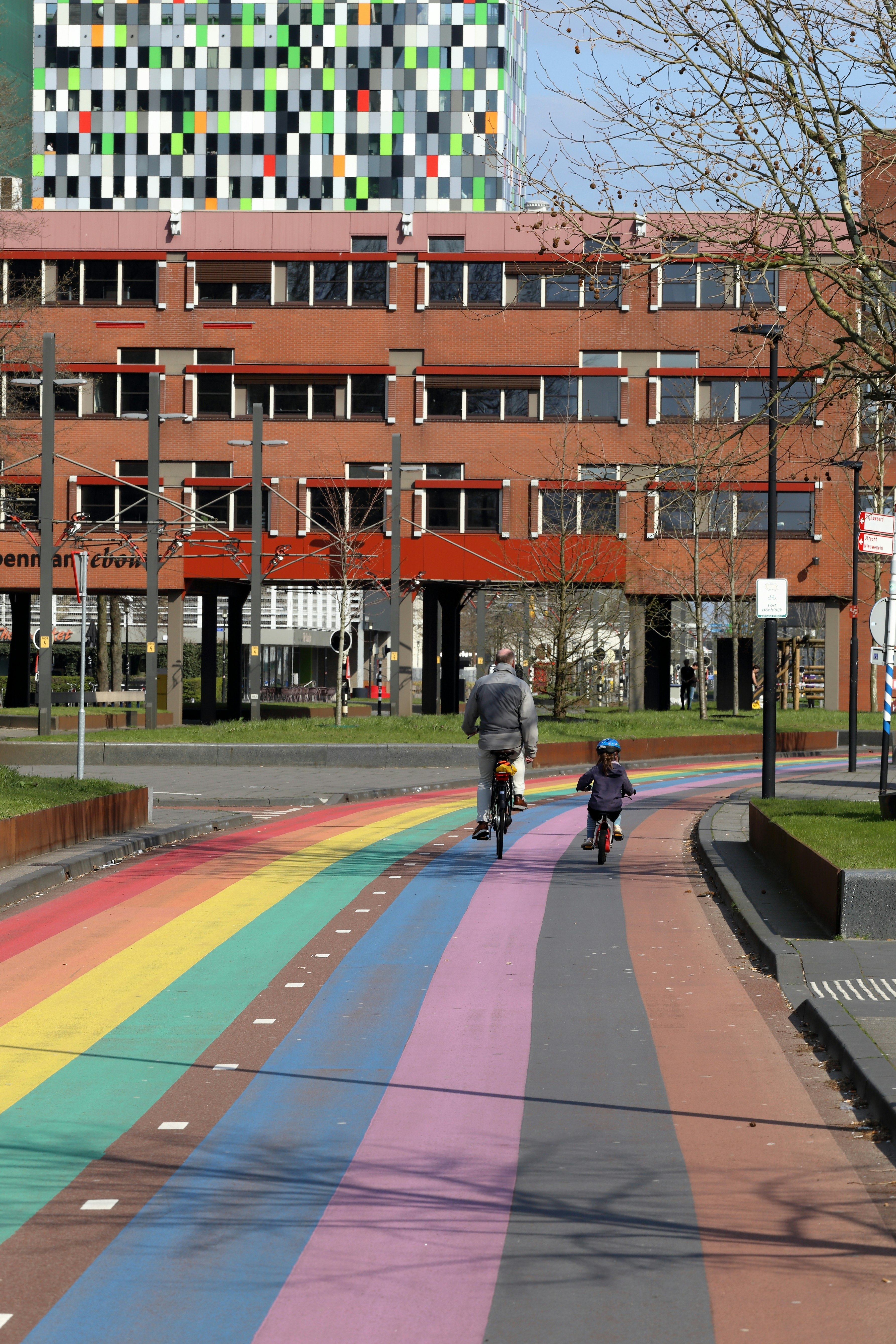 a person riding a bike down a rainbow painted street