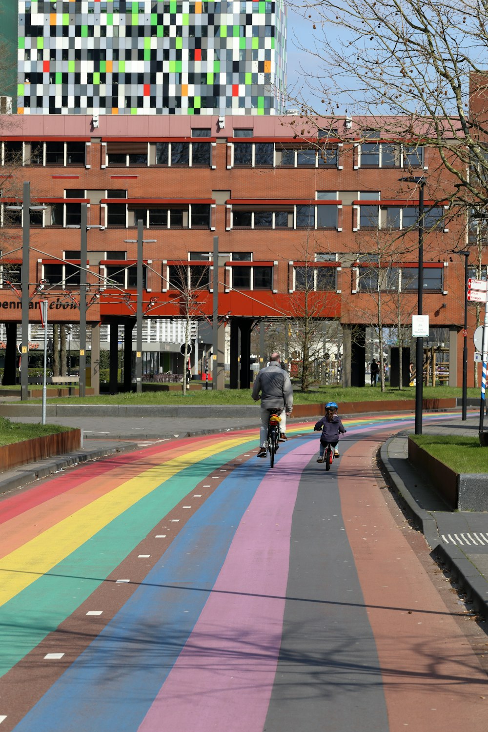 a person riding a bike down a rainbow painted street