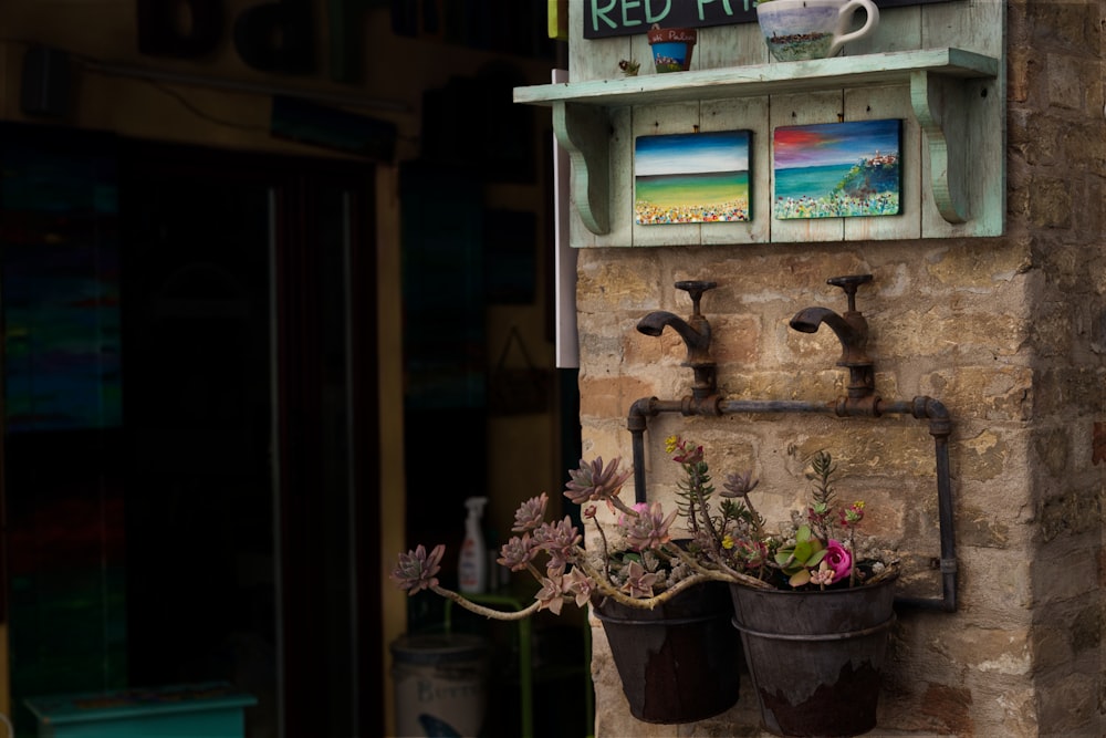 a couple of buckets filled with flowers on a wall