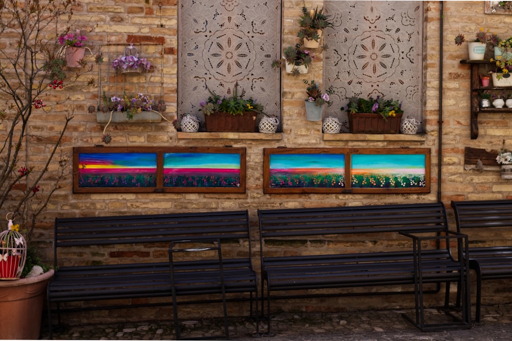 a row of benches sitting next to a brick wall