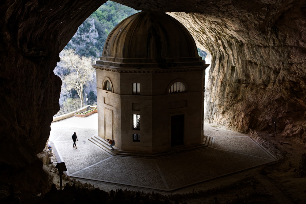 a person standing in a cave with a dome