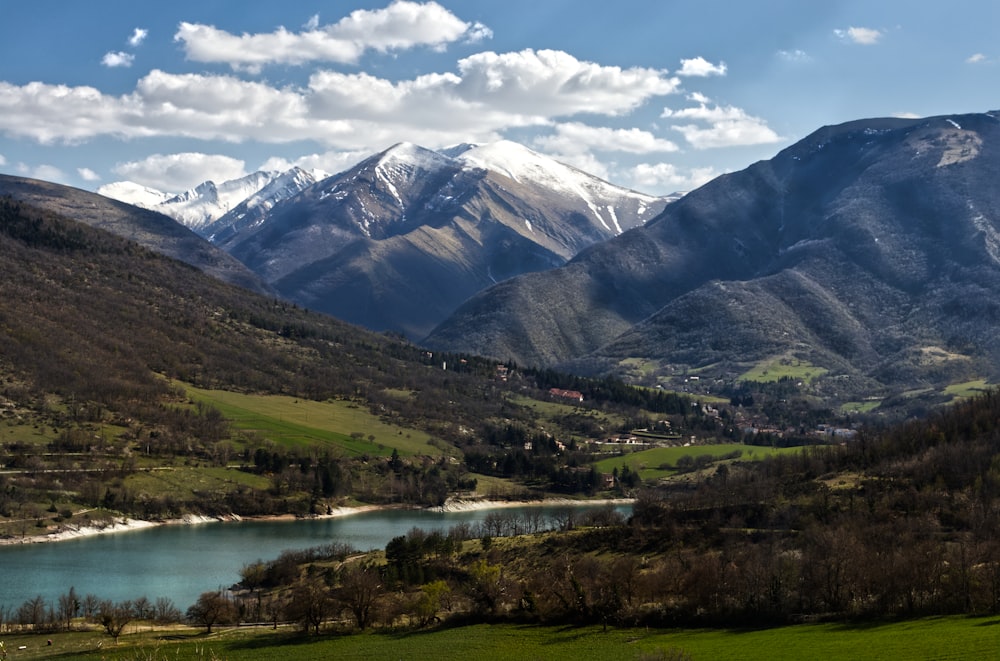 a scenic view of a mountain range with a lake in the foreground