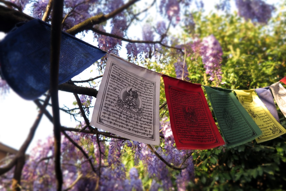 a bunch of colorful flags hanging from a tree