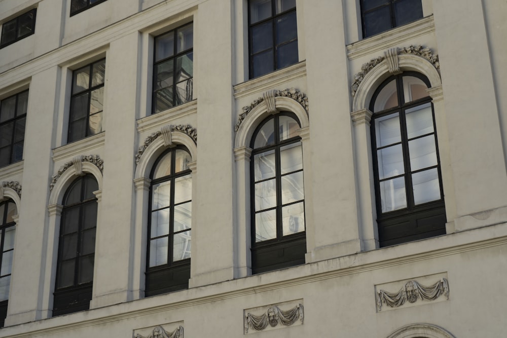 a large white building with black windows and a clock