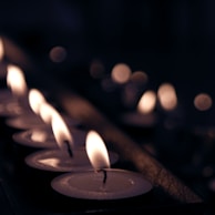 Tea light candles flickering softly inside minimalist terracotta holders on a softly lit table.