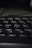 Close-up view of a black computer keyboard, with a focus on the Y, U, H, J, G, and B keys. The lighting is low, creating soft shadows and a slightly blurred depth of field in the background.