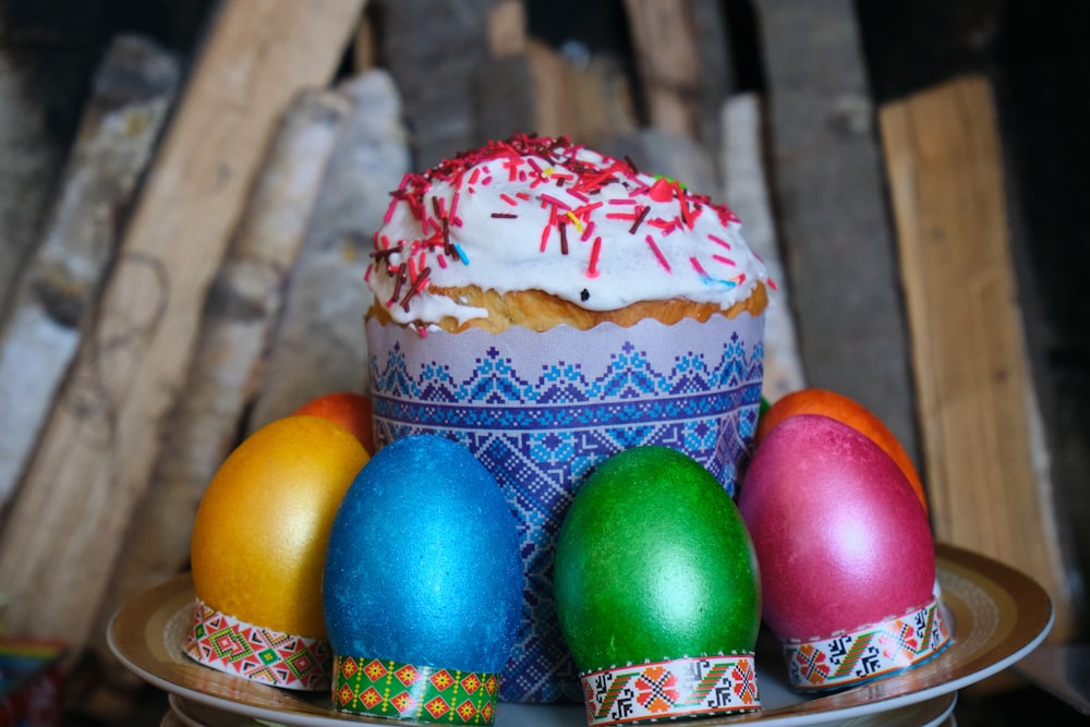 a cake with frosting, sprinkles, and decorated eggs on a