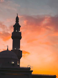Evening hues casting warm light on a mosque's minaret at sunset.