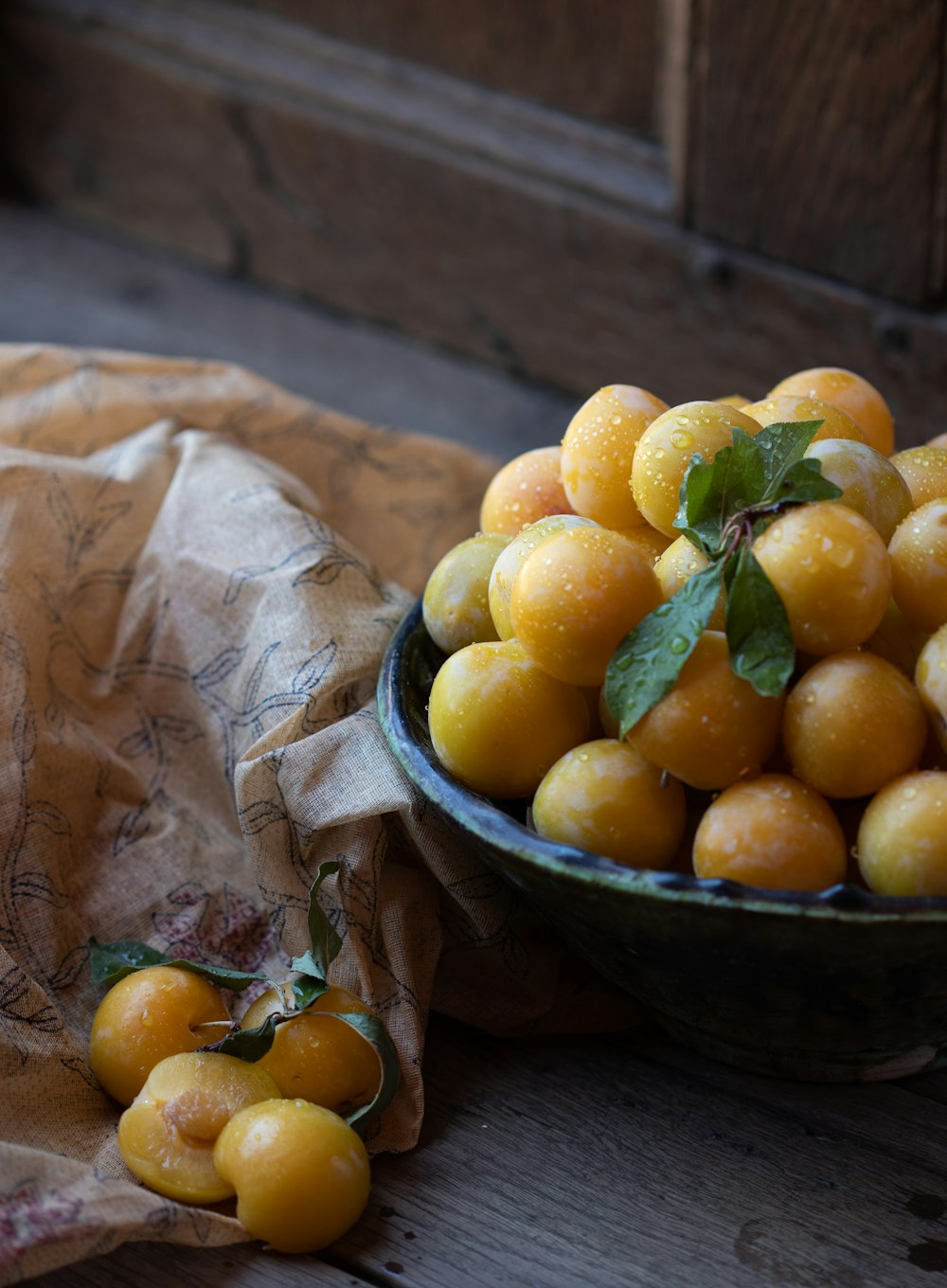 a bowl of fruit sitting on top of a wooden table