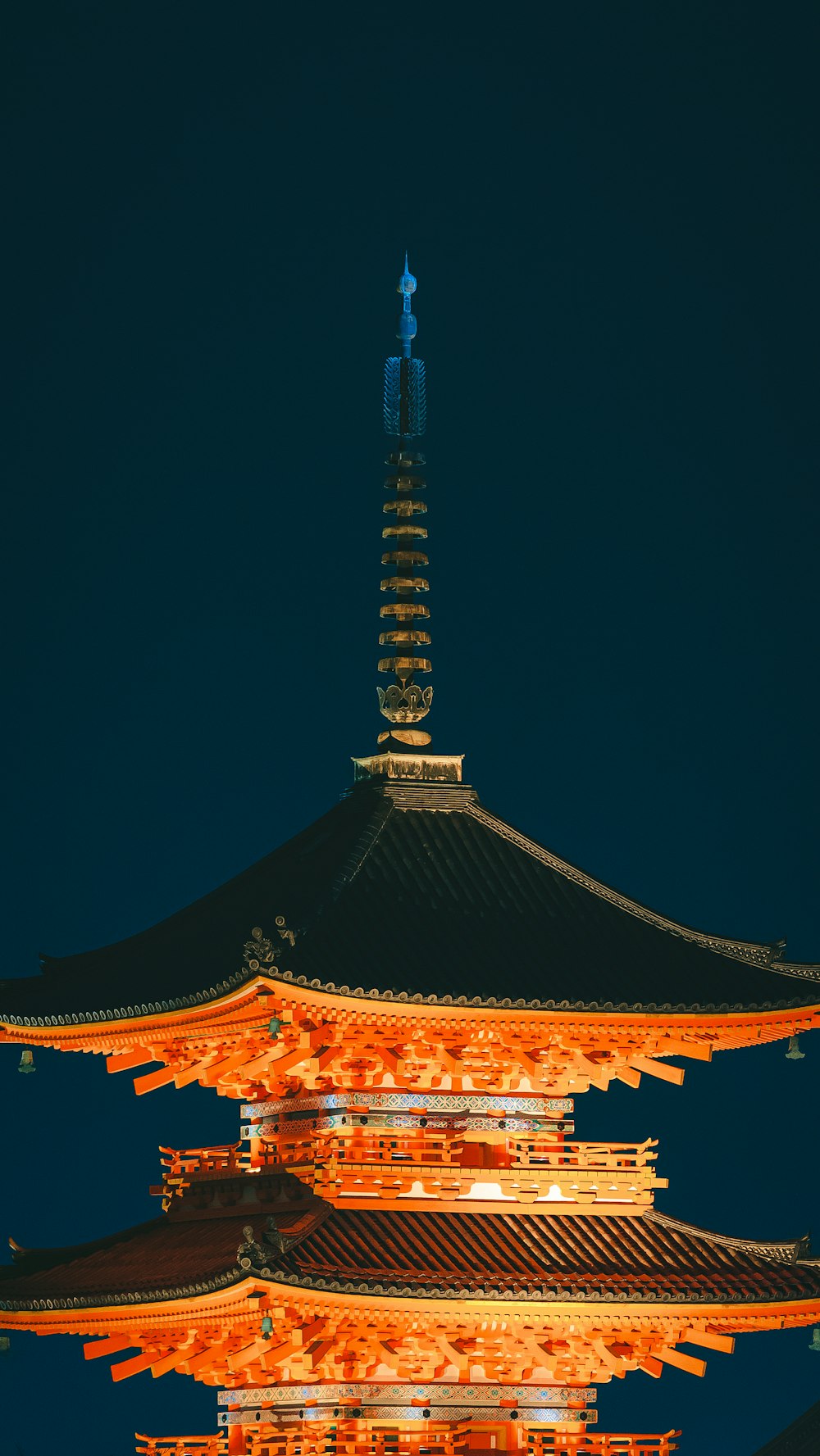 a tall building lit up at night with a sky background