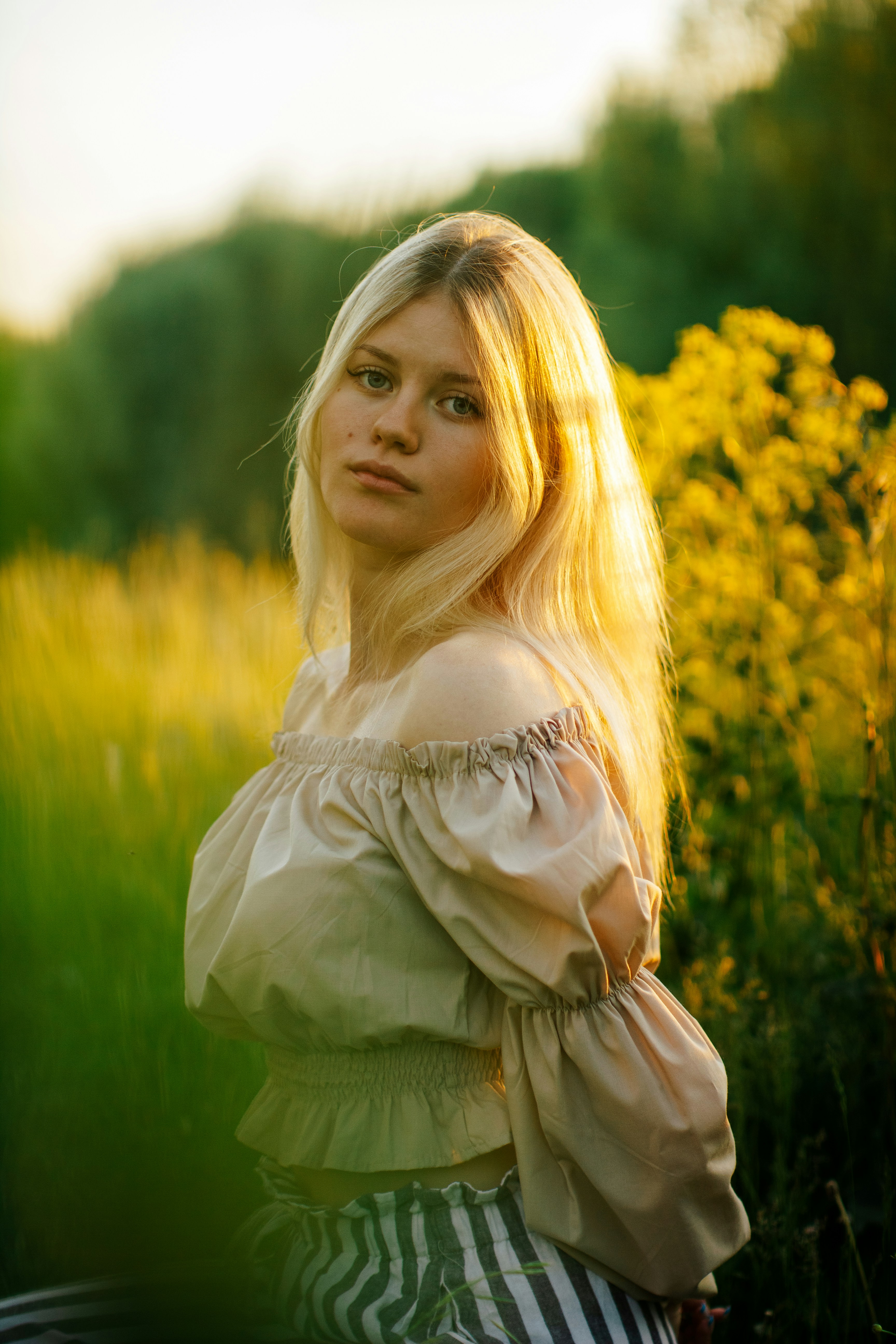 a woman standing in a field of tall grass