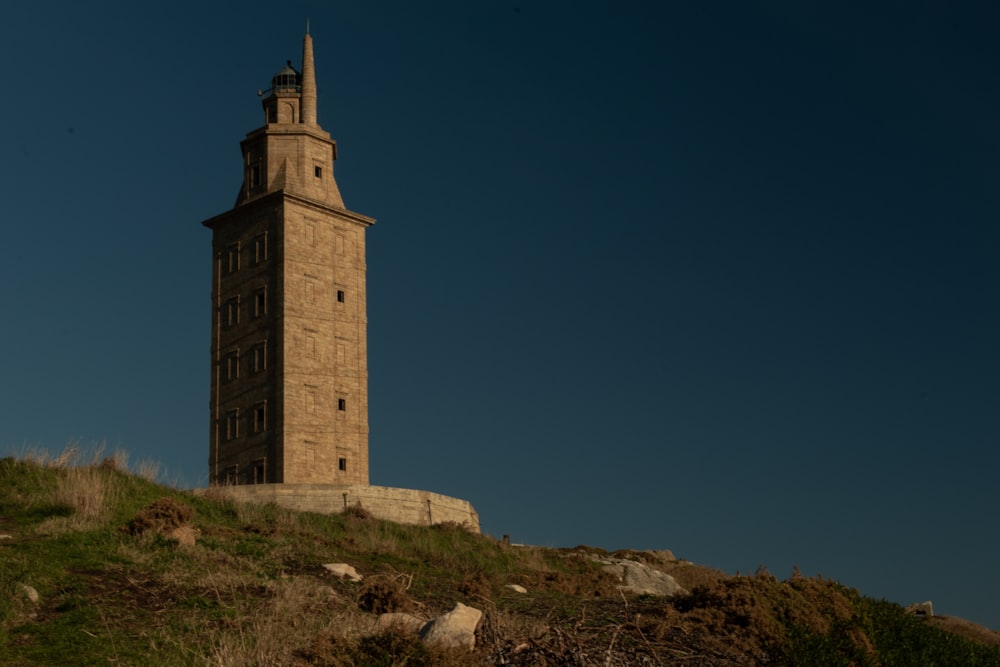 a tall tower sitting on top of a lush green hillside