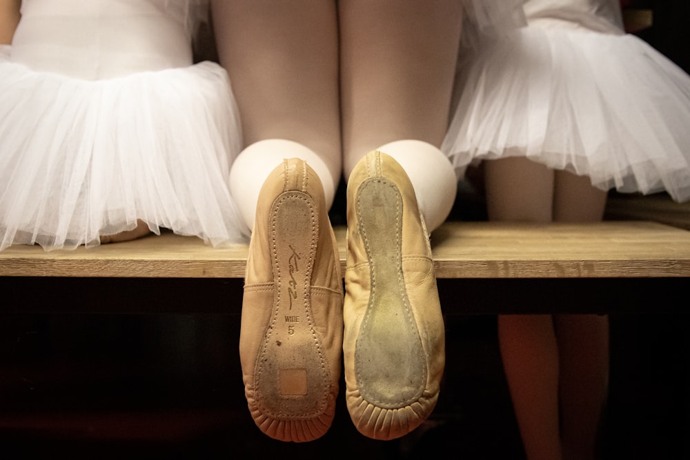 a pair of ballet shoes sitting on top of a wooden shelf