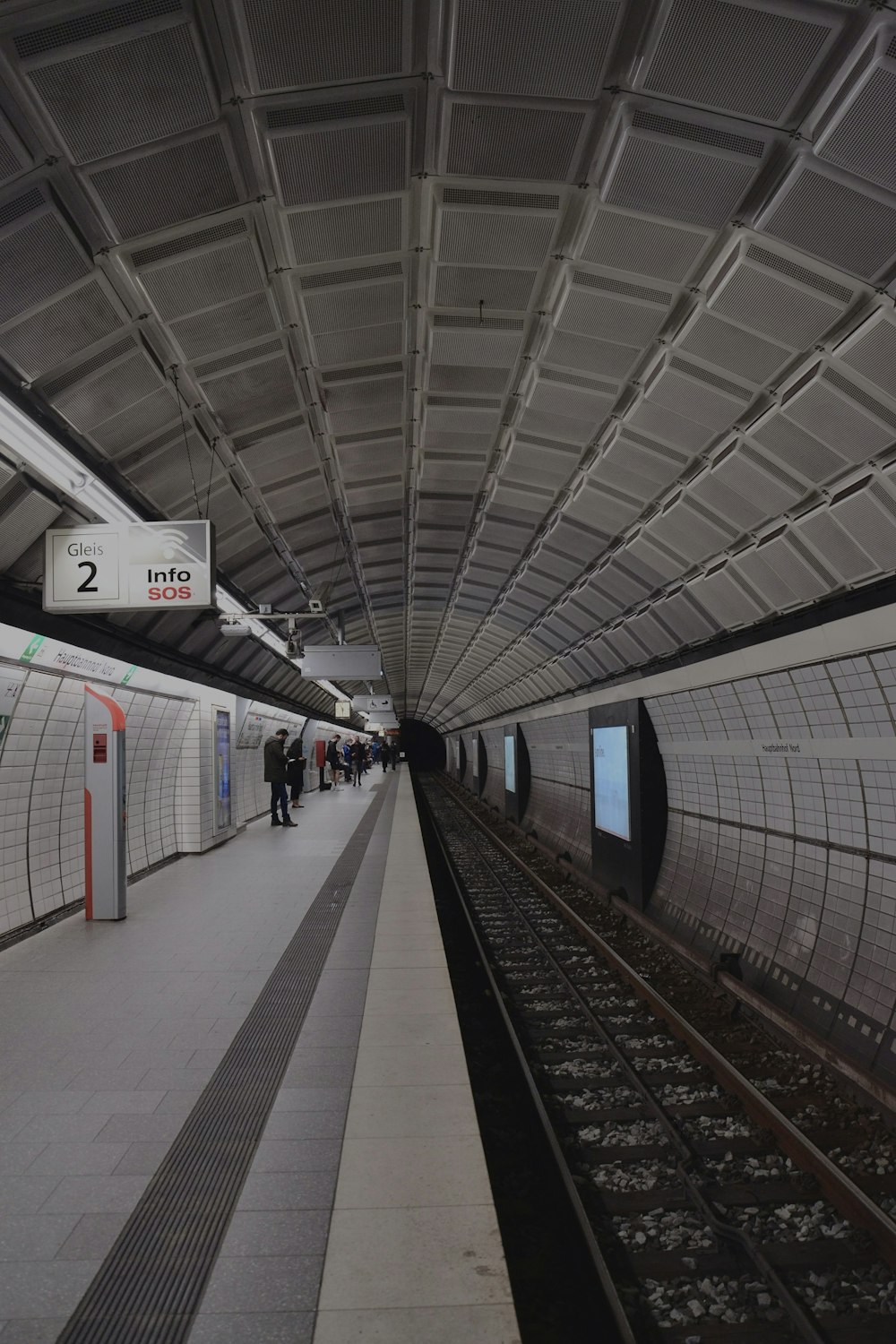 a train station with people waiting for the train