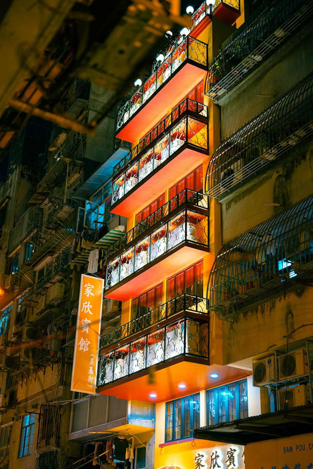 a tall building with many balconies lit up at night