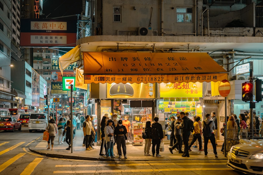 a group of people walking down a street at night