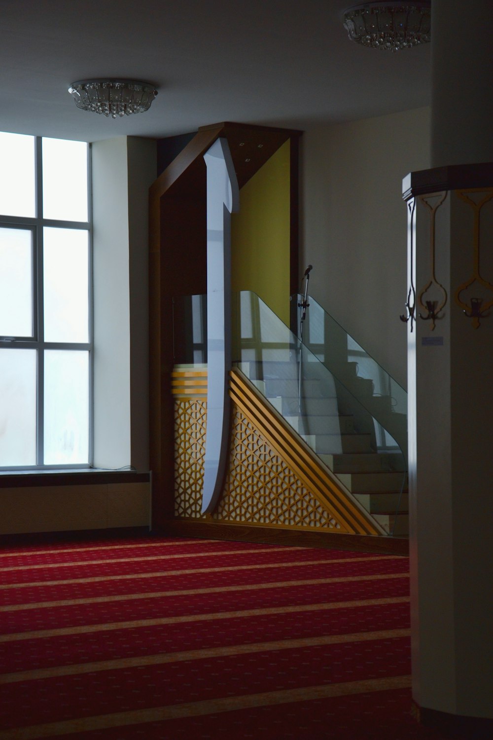 a room with a red carpet and a stair case