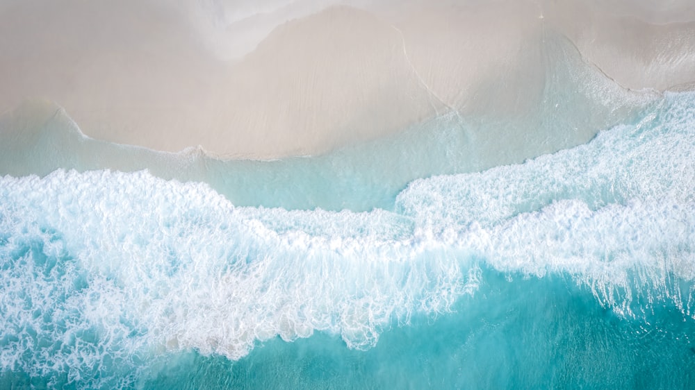 an aerial view of a beach with waves and sand