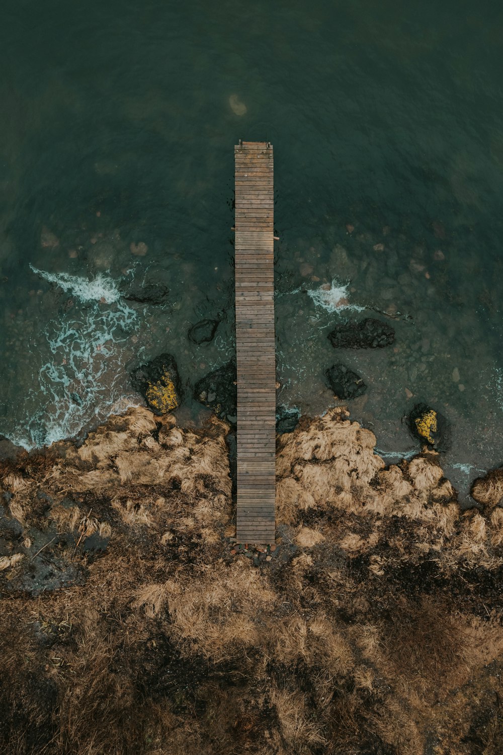 an aerial view of a pier in the water