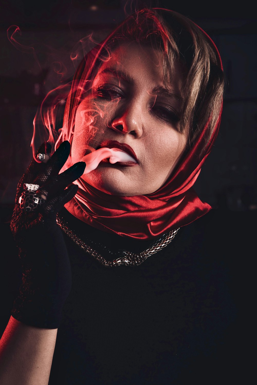 a woman in a red scarf smoking a cigarette