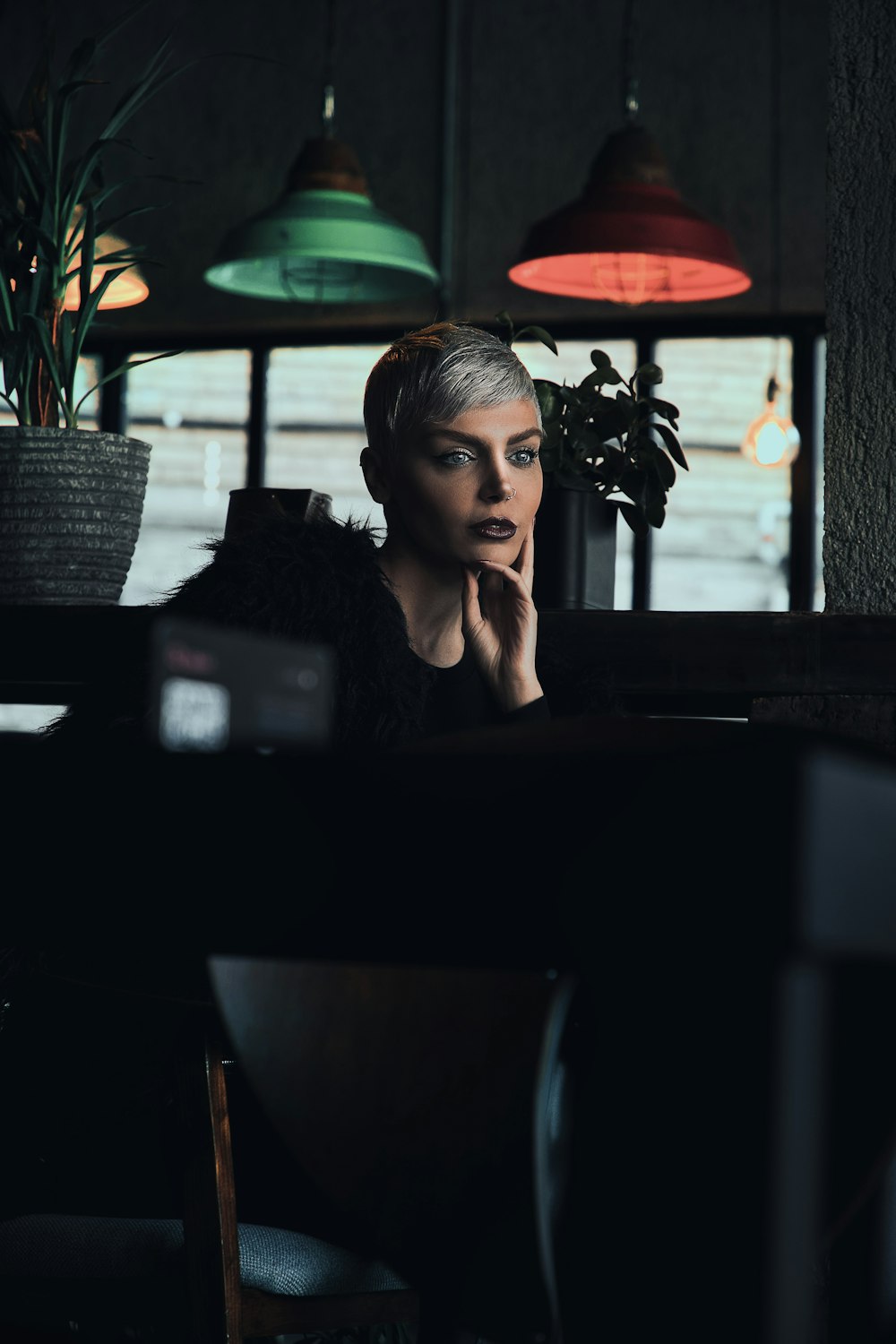 a woman sitting at a table in a dark room