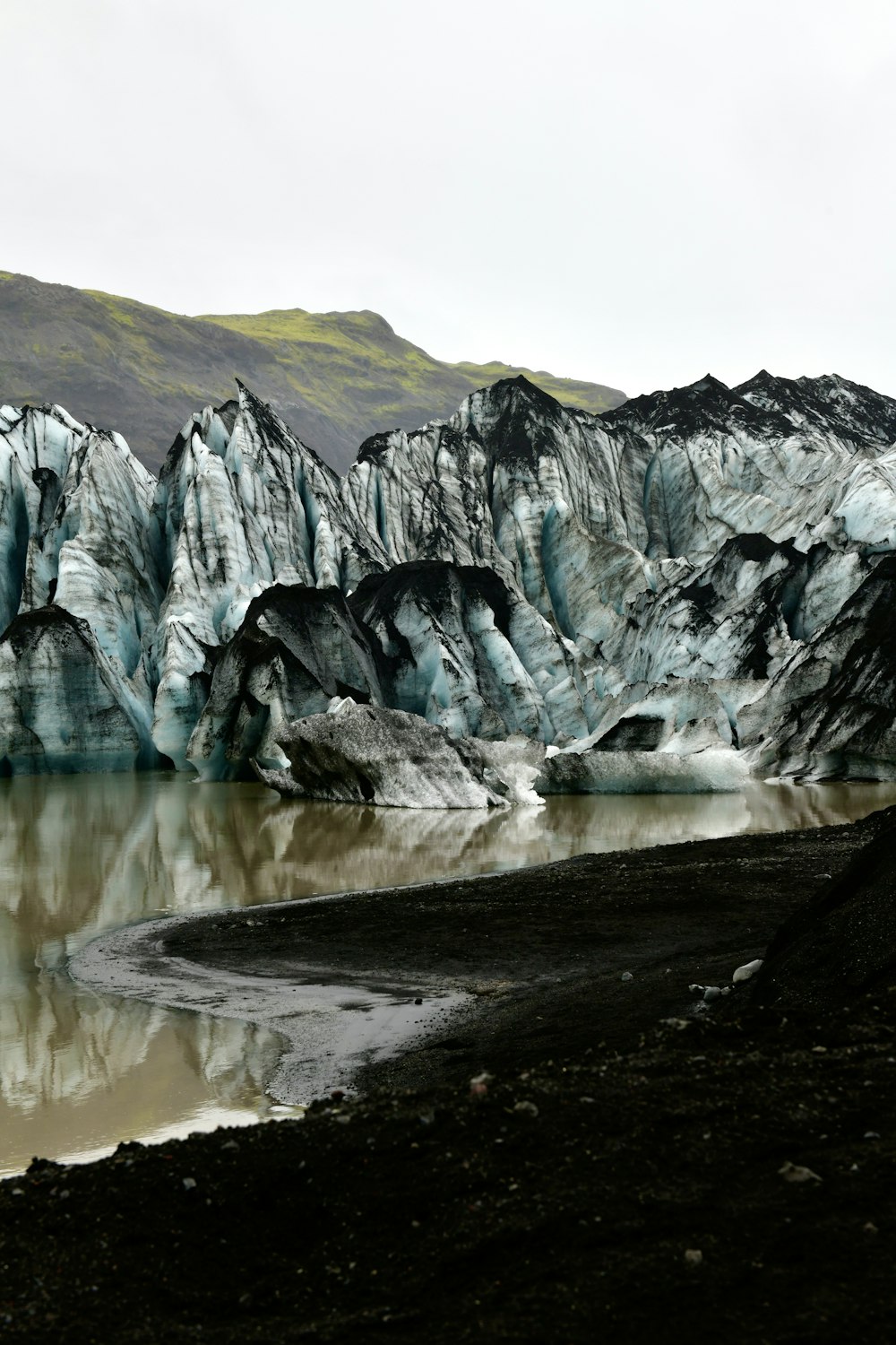 a large glacier with mountains in the background