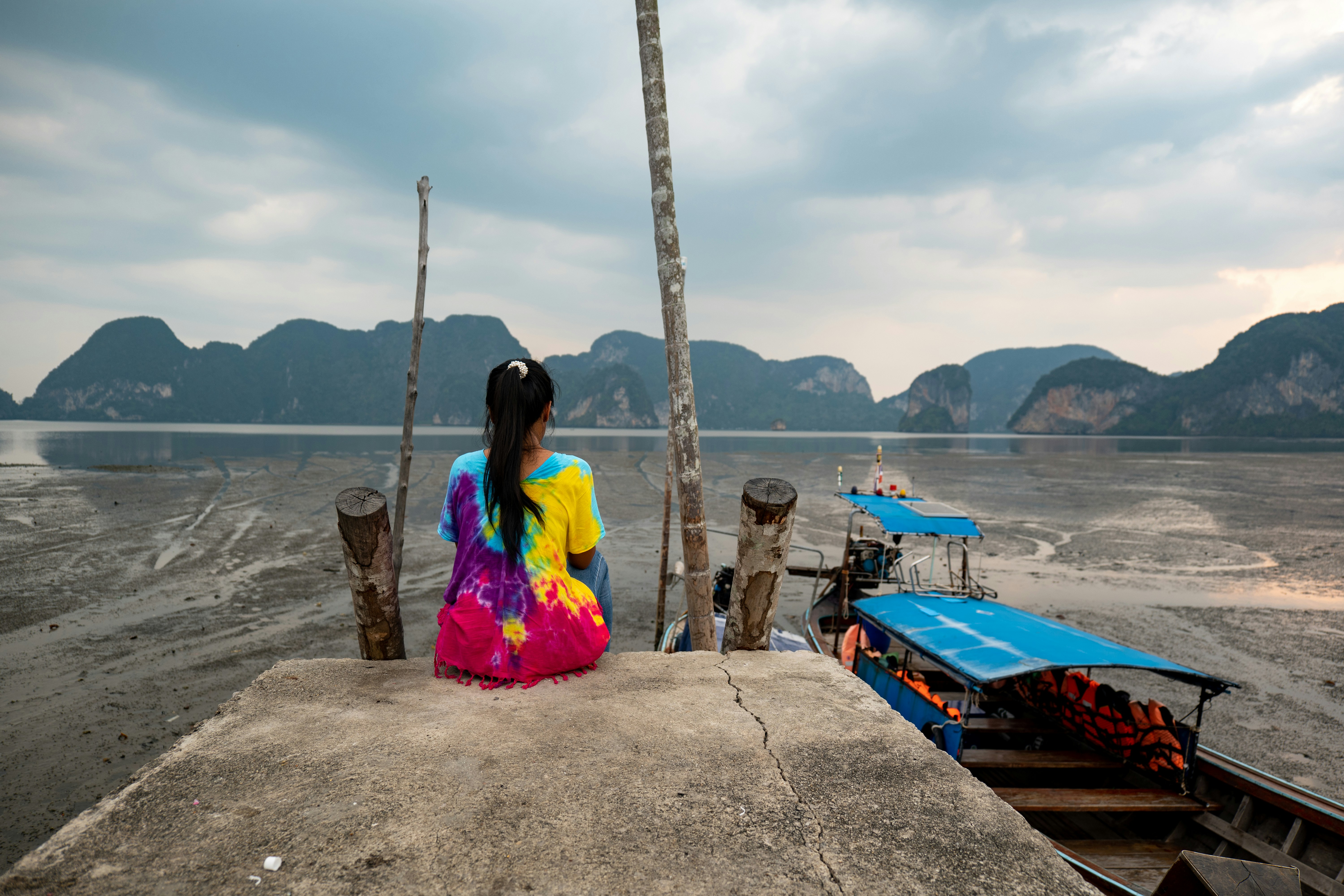 a woman sitting on a dock looking out at the water