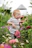 A joyful child wearing colorful, stylish clothes from éclat jardin playing in a sunny garden.
