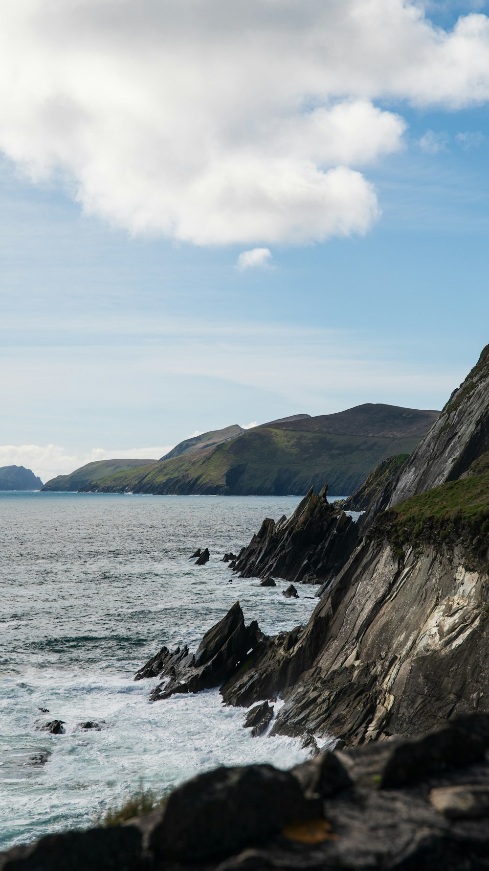 a large body of water sitting next to a rocky shore