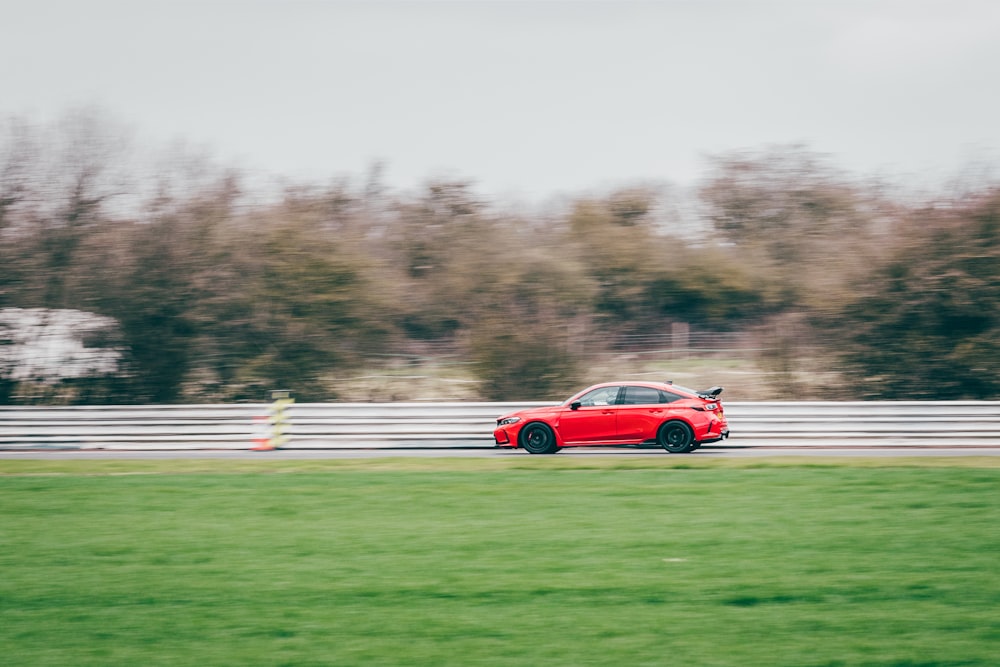 a red car driving down a race track