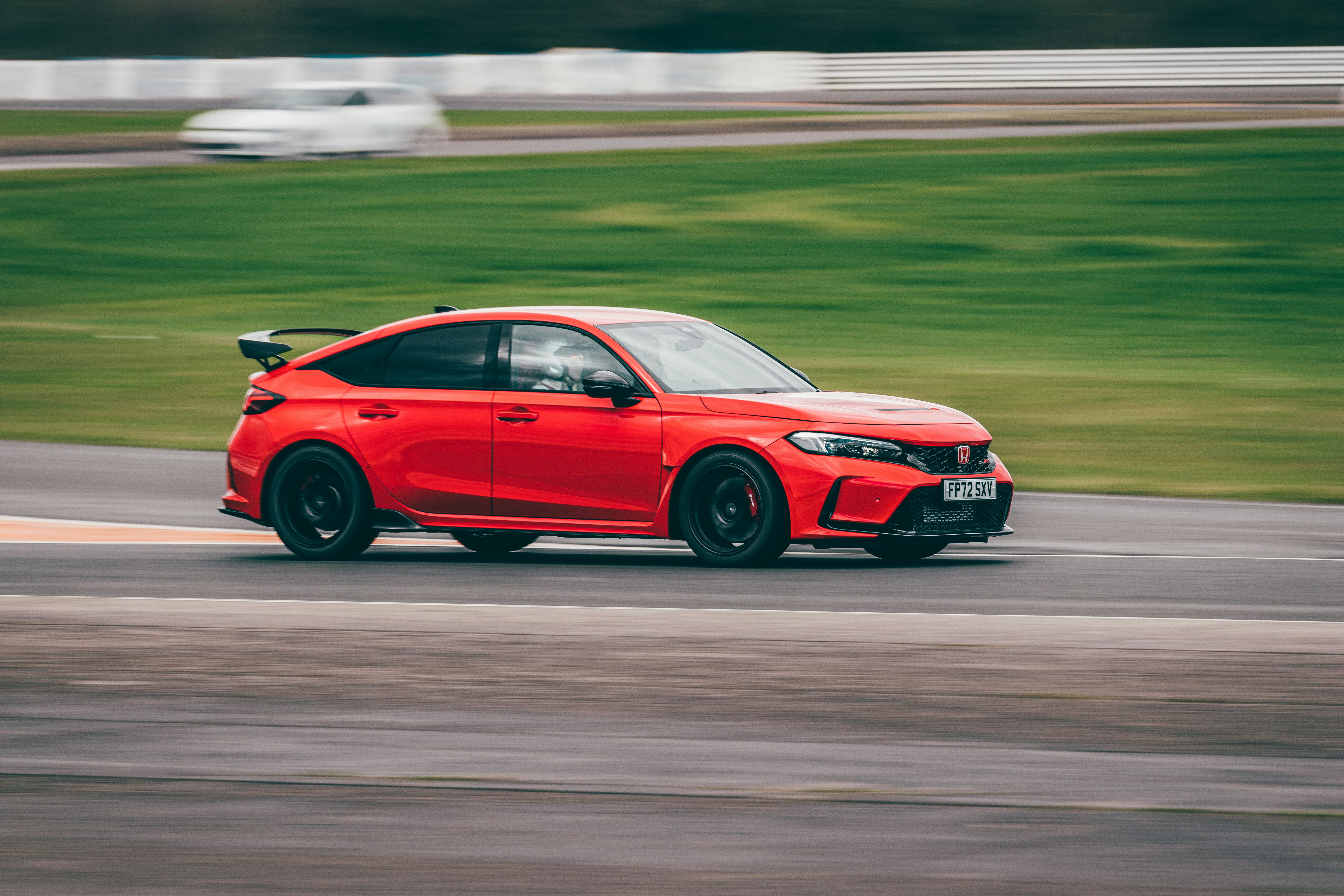 A red car driving down a race track photo – Free Uk Image on Unsplash