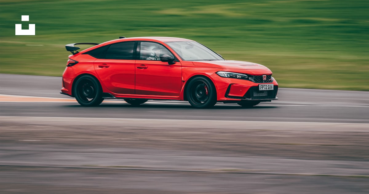 A red car driving down a race track photo – Free Uk Image on Unsplash