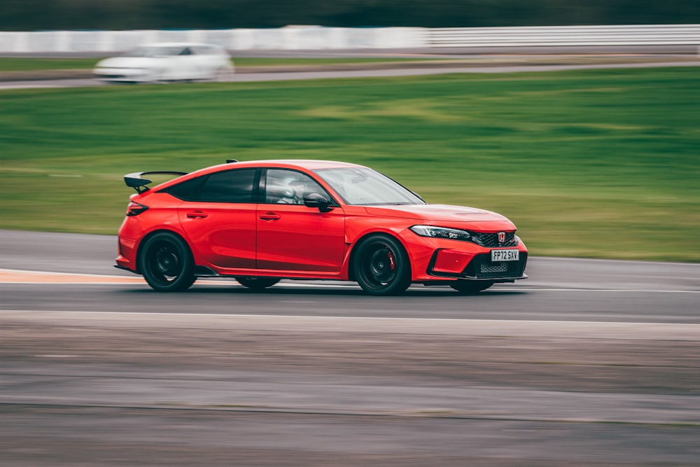 a red car driving down a race track