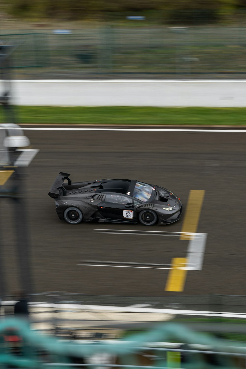 a black race car driving down a race track