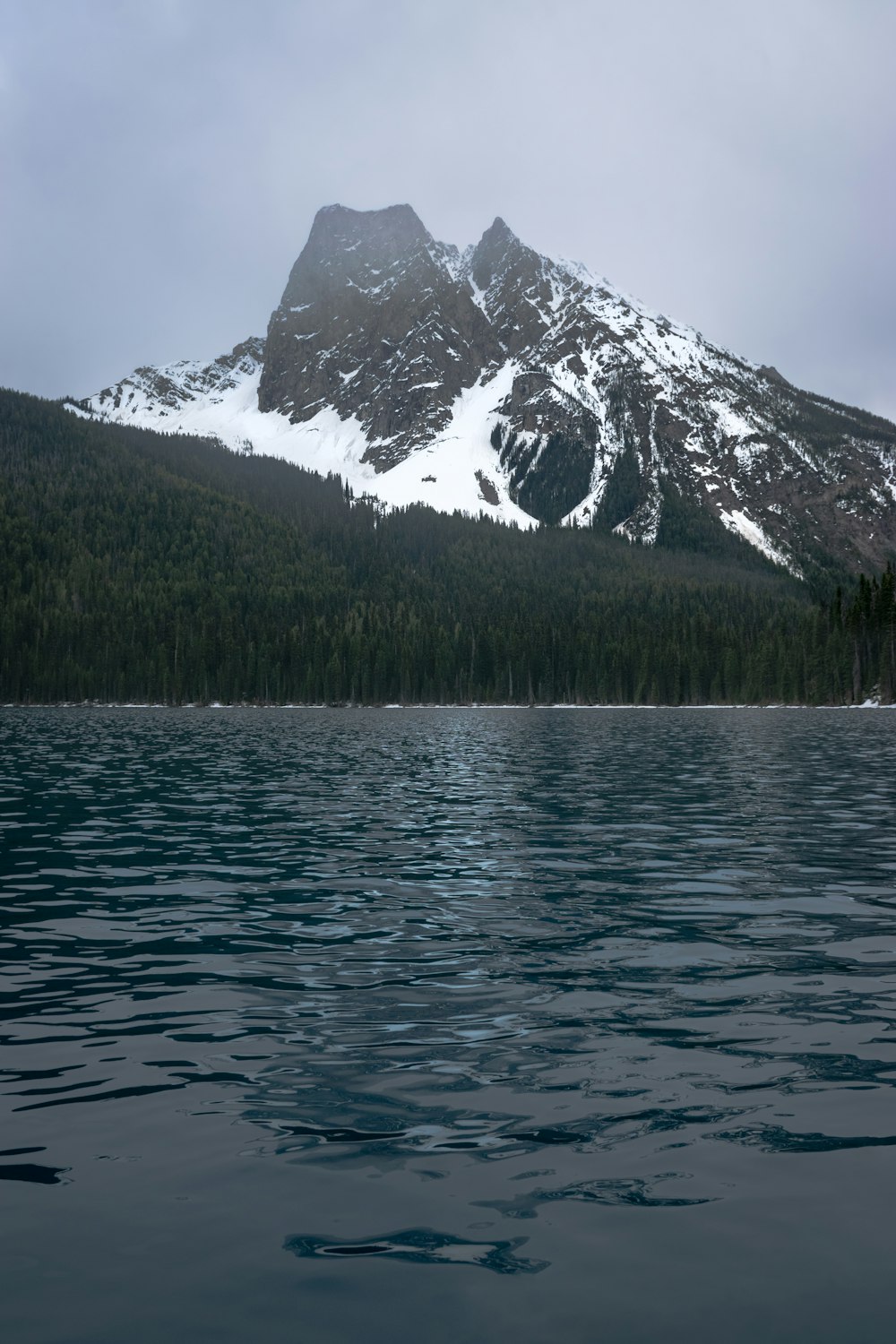 a mountain with snow on it and a body of water