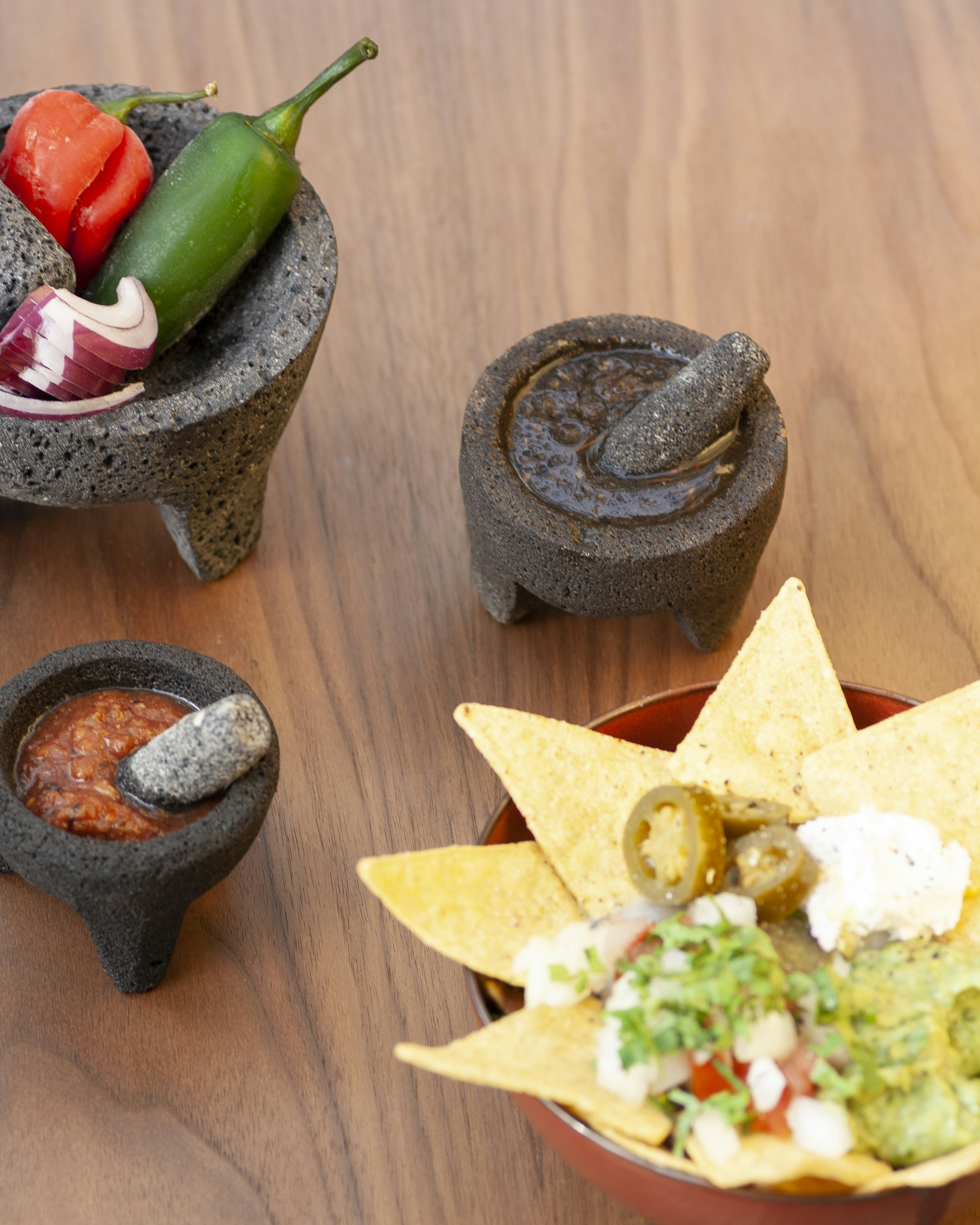a wooden table topped with bowls filled with food
