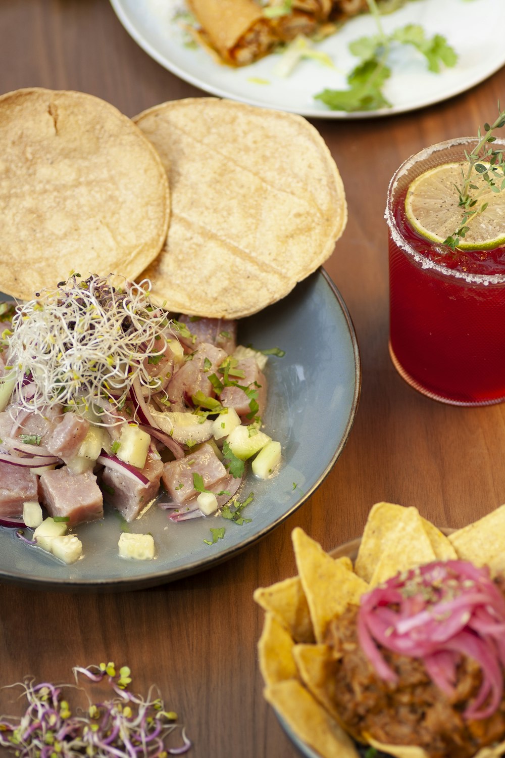 a wooden table topped with plates of food and drinks