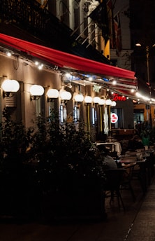 A cozy outdoor seating area with warm lighting and rock-themed decor at night.