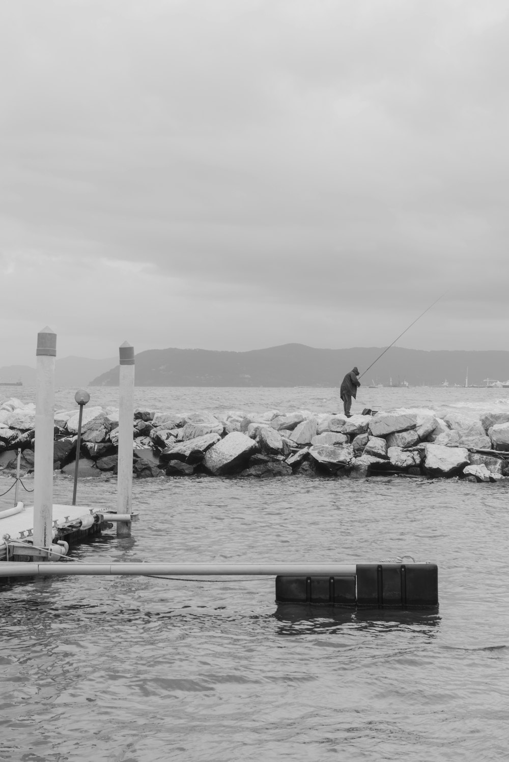 a black and white photo of a man fishing