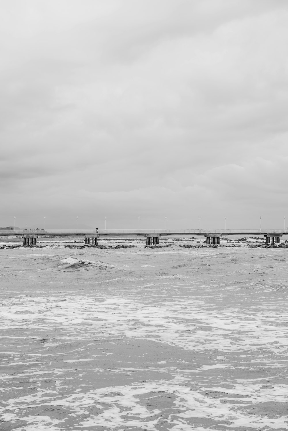 a black and white photo of a bridge over water