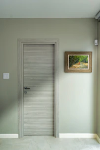 an empty room with a door and a picture on the wall