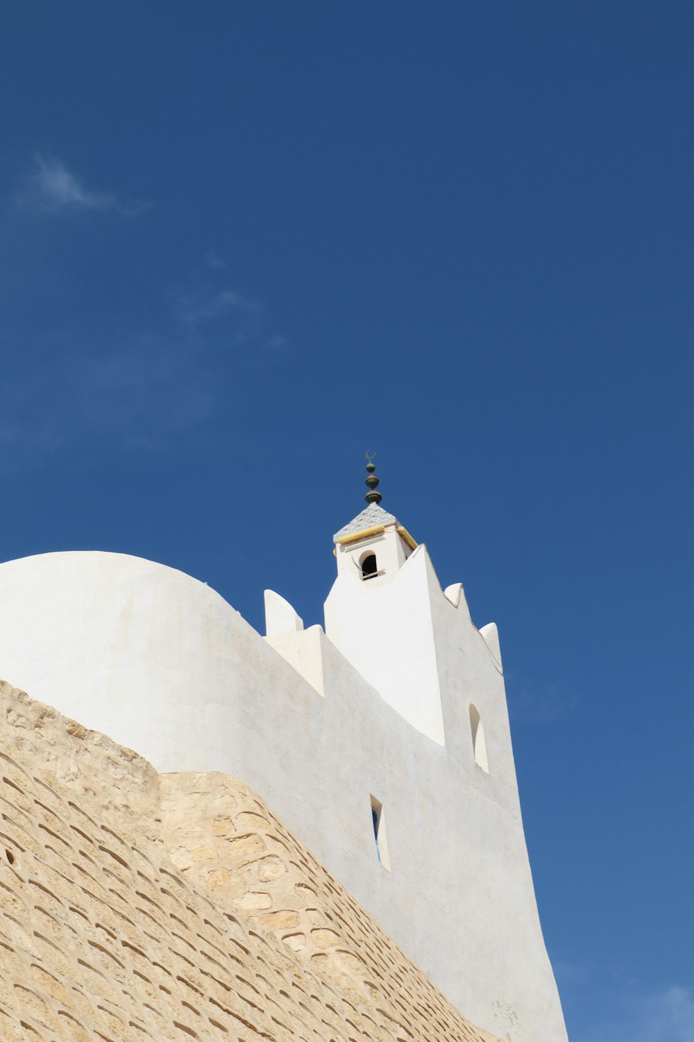 a tall white building with a clock on it's side