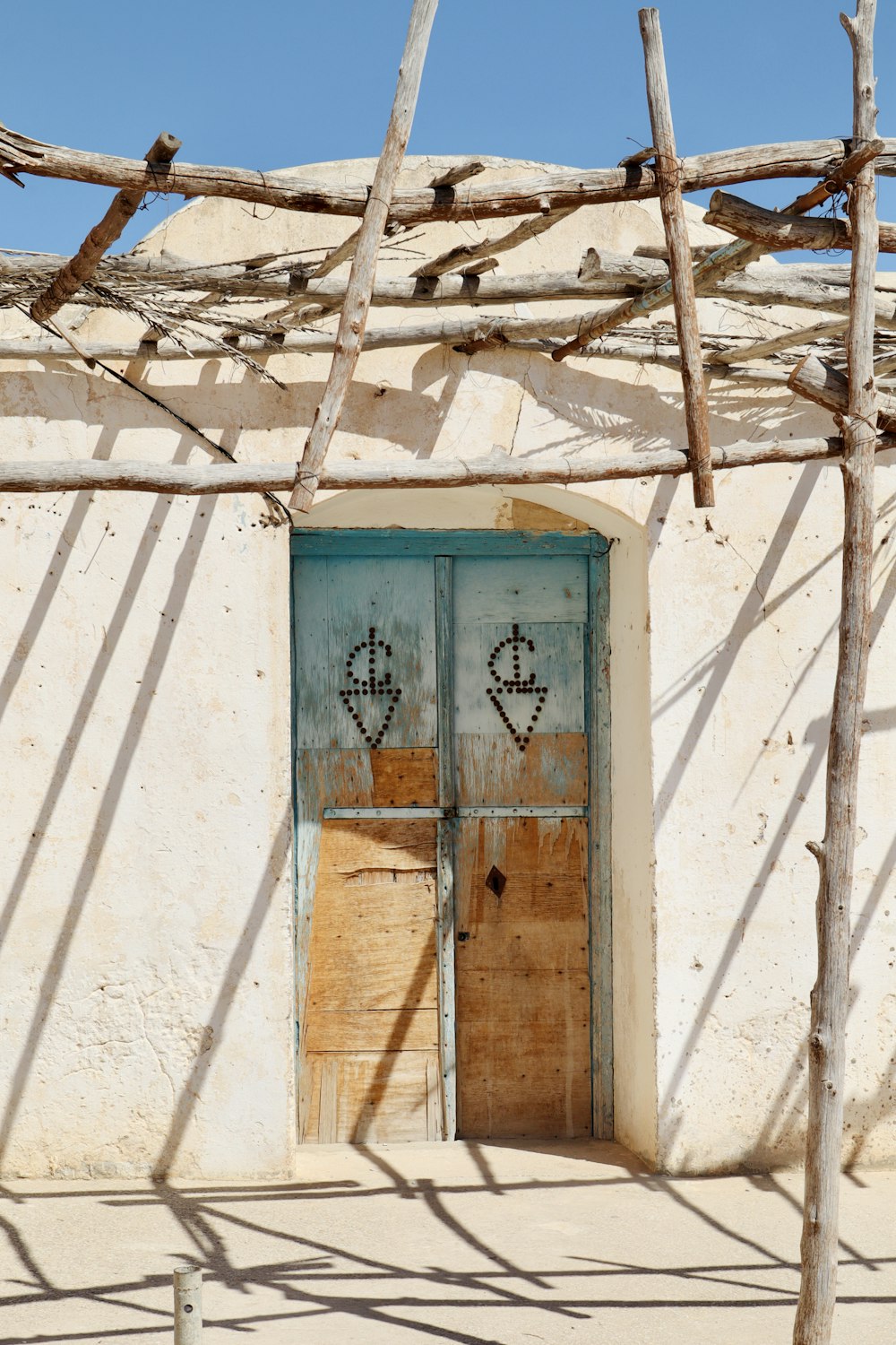 a door with two faces on it in front of a building