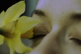 a close up of a person holding a flower