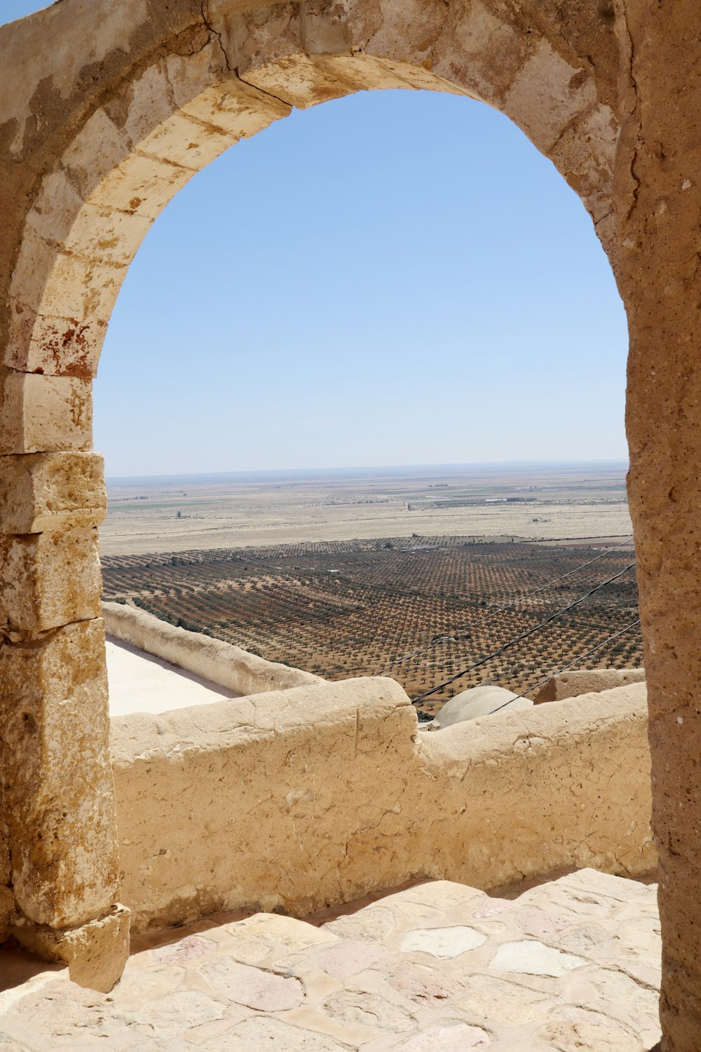 a stone arch with a view of a desert