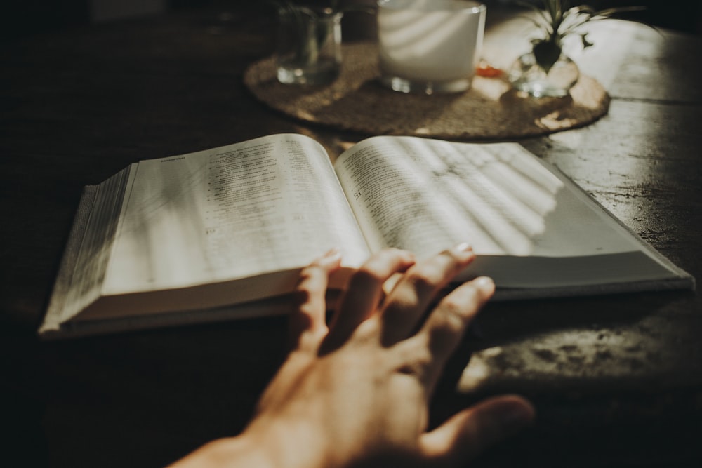 a person is reading a book on a table