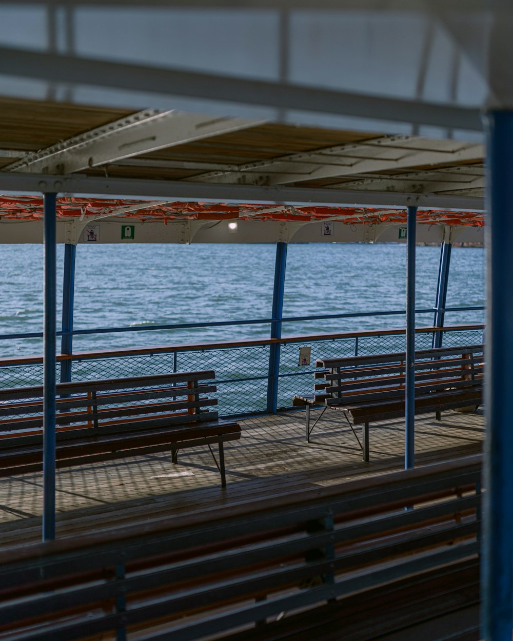 a row of benches sitting next to a body of water