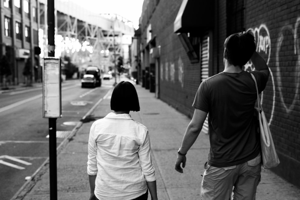 a man and a woman walking down a sidewalk